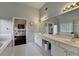 Bathroom with white cabinets, a long countertop, and a large mirror, complemented by tile flooring at 350 River Walk Ter, Johns Creek, GA 30024