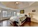 Sunlit bedroom with hardwood floors, tray ceiling, and a bay window with a garden view at 350 River Walk Ter, Johns Creek, GA 30024