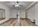 Open living room with wood floors, a ceiling fan, and access to other areas of the home at 350 River Walk Ter, Johns Creek, GA 30024