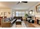 Open living area with hardwood floors, large sectional sofa, and a brick fireplace at 350 River Walk Ter, Johns Creek, GA 30024