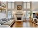 Cozy living room featuring hardwood floors, a fireplace, and large windows at 350 River Walk Ter, Johns Creek, GA 30024