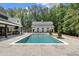 Beautiful backyard oasis featuring a large in-ground pool and a separate pool house, surrounded by mature trees at 504 Trinity Church Rd, Canton, GA 30115