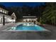 Well-lit backyard with an in-ground pool and separate pool house, creating an inviting outdoor space at night at 504 Trinity Church Rd, Canton, GA 30115