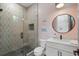 Modern bathroom with a glass-enclosed shower featuring stylish tilework and a black-framed round mirror at 504 Trinity Church Rd, Canton, GA 30115