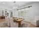 Bright dining room featuring wood table for six, modern chandelier and rug, and stylish white accent chairs at 504 Trinity Church Rd, Canton, GA 30115