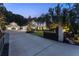 Twilight view of a beautiful home with long driveway, black iron fence, and three-car garage at 504 Trinity Church Rd, Canton, GA 30115
