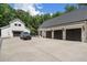 This modern farmhouse has a three car garage plus a barn garage with a black car parked on the concrete pad at 504 Trinity Church Rd, Canton, GA 30115