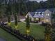 Charming two-story home featuring well-manicured lawn, a gated entrance, and a black picket fence with tasteful lighting at 504 Trinity Church Rd, Canton, GA 30115