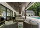 Covered outdoor patio with a lounge area and outdoor kitchen overlooking a pool and backyard at 504 Trinity Church Rd, Canton, GA 30115