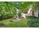 Landscaped backyard featuring a stone patio with fire pit, lush greenery, and ample space at 118 Chelsea Dr, Decatur, GA 30030