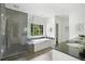 Modern bathroom features a soaking tub by a window and frameless glass shower at 118 Chelsea Dr, Decatur, GA 30030