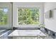 Large soaking tub under large window brings nature inside of a bright bathroom at 118 Chelsea Dr, Decatur, GA 30030
