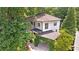 Two-story home with vine-covered carport, upper balcony, and a surrounding of large trees at 118 Chelsea Dr, Decatur, GA 30030