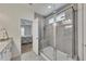 Tiled shower with glass door in updated bathroom with tiled floor and access to bedroom at 320 Pebblestone Ln, Canton, GA 30115