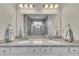 Bathroom with double sinks, granite countertops, tiled shower, and large vanity mirror at 320 Pebblestone Ln, Canton, GA 30115
