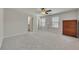 Large, neutral-toned bedroom with plush carpet, two sunny windows, ceiling fan, and bureau at 320 Pebblestone Ln, Canton, GA 30115