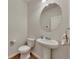 Cozy half bathroom featuring a pedestal sink, an oval mirror, and a modern toilet at 320 Pebblestone Ln, Canton, GA 30115