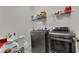Laundry room with a washer, dryer, utility sink, and shelving for storage at 320 Pebblestone Ln, Canton, GA 30115