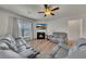 Bright and airy living room featuring a fireplace, comfortable seating, and a ceiling fan at 320 Pebblestone Ln, Canton, GA 30115