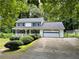 Charming two-story home with a front porch, attached garage and well-manicured landscaping at 460 Heathrow Way, Stone Mountain, GA 30087