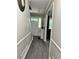 Hallway with gray wood flooring, entry door, and view into living room at 460 Heathrow Way, Stone Mountain, GA 30087