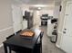 Bright kitchen featuring white cabinetry and stainless steel appliances with view of dining area at 460 Heathrow Way, Stone Mountain, GA 30087
