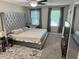 Main bedroom with a decorative headboard, large window, and modern ceiling fan at 460 Heathrow Way, Stone Mountain, GA 30087
