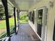 Open front porch featuring covered space with wood flooring, front door, and view of the surrounding yard at 460 Heathrow Way, Stone Mountain, GA 30087