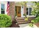 Close up of the beautiful wood front door with glass, brick steps, lush greenery, and an American flag at 113 Stargaze Rdg, Canton, GA 30114