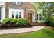 Inviting front entrance with brick steps, arched doorway, beautiful wood door, and neatly trimmed shrubs at 113 Stargaze Rdg, Canton, GA 30114