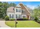 Charming two-story home with a brick facade, light blue siding, and a manicured lawn in a tree-lined neighborhood at 113 Stargaze Rdg, Canton, GA 30114