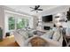 Bright living room featuring built-in shelves, a fireplace, and large windows showcasing the outdoors at 113 Stargaze Rdg, Canton, GA 30114