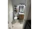 Charming bathroom featuring patterned tile flooring, modern vanity, and stylish shelving for optimal storage at 276 Colewood Nw Way, Atlanta, GA 30328