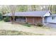 Charming brick home with a covered porch, mature trees, and well-maintained landscaping at 276 Colewood Nw Way, Atlanta, GA 30328