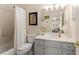 Well-lit bathroom featuring a tub and shower, a white vanity, and decorative mirror at 4789 Crest Park Ln, Marietta, GA 30068