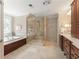 Bathroom featuring a glass shower enclosure, garden tub, and double vanity with wooden cabinets at 4789 Crest Park Ln, Marietta, GA 30068