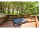 Backyard deck showcasing a relaxing hot tub surrounded by lush greenery at 4789 Crest Park Ln, Marietta, GA 30068