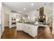 Open kitchen with island cooktop flows into the living room and its striking stone fireplace at 4789 Crest Park Ln, Marietta, GA 30068