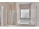 Bathroom showcasing a shower with glass door and a separate tub with tile accents and fixtures at 903 Duncan Ter, Canton, GA 30115