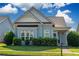 Charming blue home featuring manicured landscaping, a covered front porch, and decorative gable detailing at 903 Duncan Ter, Canton, GA 30115
