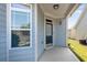 Covered front porch featuring blue siding, a storm door, and ample natural light through the window at 903 Duncan Ter, Canton, GA 30115