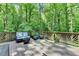 A deck with an outdoor seating area with a lush, green forest beyond at 1595 Northcliff Trce, Roswell, GA 30076