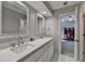 Bathroom features double sinks, marble countertop, white cabinets, and an open door to an adjacent room at 1595 Northcliff Trce, Roswell, GA 30076