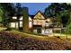 Rear exterior of the home showcasing the deck and basement patio with wooded views at dusk at 1595 Northcliff Trce, Roswell, GA 30076