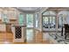 Open-concept kitchen with island, wine rack, and hardwood floors, seamlessly connecting to a screened patio through French doors at 1595 Northcliff Trce, Roswell, GA 30076