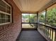 Screened back porch with brick wall on one side, a view into the neighborhood, and wood-look vinyl flooring at 425 Bell Flower Trl, Locust Grove, GA 30248