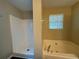 This bathroom features a shower and jetted tub with tile; all complemented by wood-look vinyl floors at 425 Bell Flower Trl, Locust Grove, GA 30248