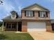 Charming two-story brick home with a well-manicured lawn and attached two car garage at 425 Bell Flower Trl, Locust Grove, GA 30248