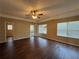 Spacious living room with tray ceiling, ceiling fan, wood-look vinyl flooring, and french doors leading outside at 425 Bell Flower Trl, Locust Grove, GA 30248