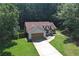 An aerial view captures the home's location, showcasing the lush green surroundings and long driveway at 106 Kimbell Farm Dr, Locust Grove, GA 30248